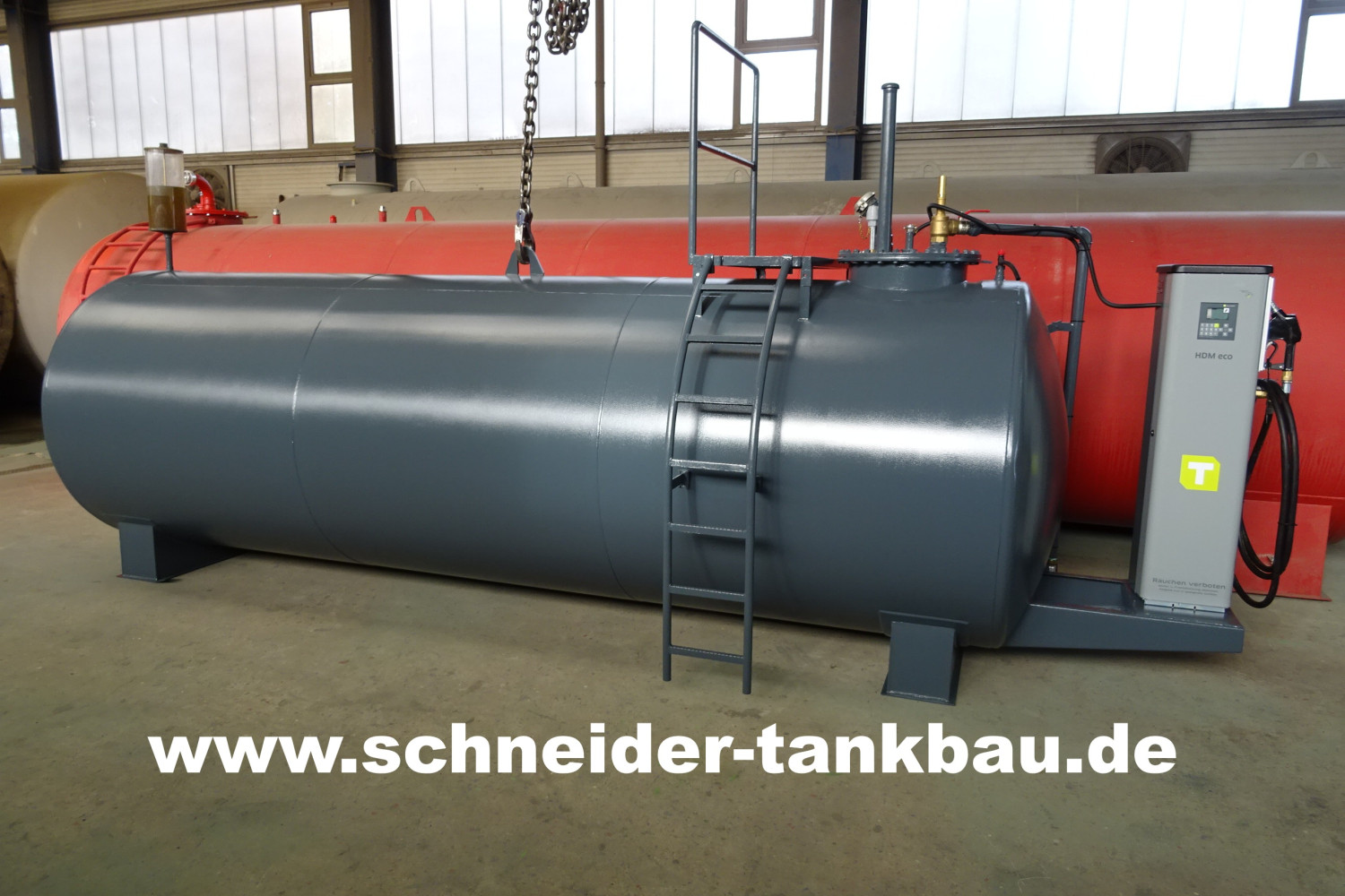 Grauer Dieseltank mit 10.000 Liter Fassungsvermögen und montierter Zapfsäule in einer Halle.