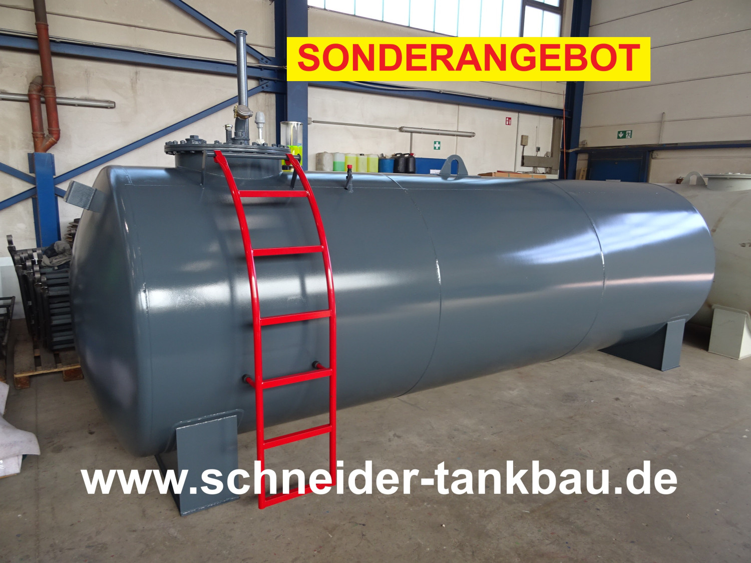 Grauer Dieseltank mit 10.000 Liter Fassungsvermögen und roter Leiter in einer Halle.