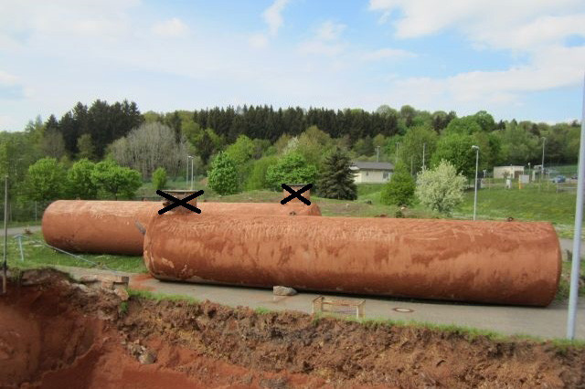 Zwei gebrauchte 100.000 Liter Erdtanks vor Baugrube bereit zum Abtransport.