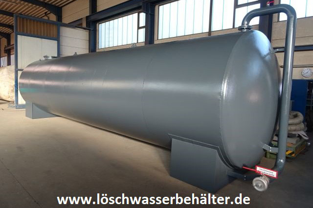 Grauer Löschwassertank mit 50.000 Liter Fassungsvermögen und Anschlussleitungen in einer Halle.