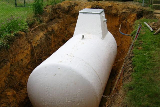 Weißer 7.000 Liter Dieseltank mit Domschacht eingelassen in eine Baugrube. 