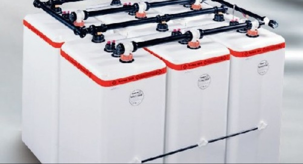Vier weiße Heizöltanks aus Kunststoff, zusammengeschlossen mit Verrohrung und Anschlüssen zu einer Tank-Batterie.