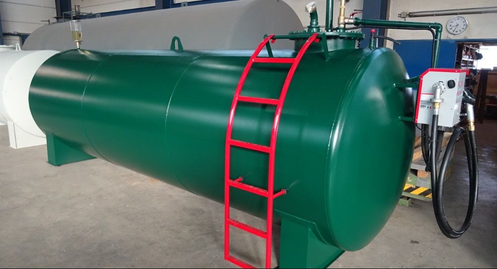 Dunkelgrüner horizontaler Lagertank mit roter Leiter und angeschlossener Zapfanlage.