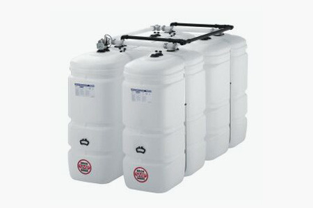 vier 1000 Liter große, weiße Heizöltanks aus Kunststoff, auf der Oberseite mit Leitungen miteinander verbunden